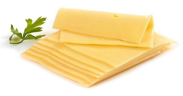 White isolated background. 7 sliced cheddar cheese on top of each other